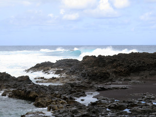 Fototapeta na wymiar scrambled sea waves crashing against lava rocks