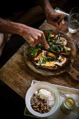 Man eating raw vegan pizza on wooden table