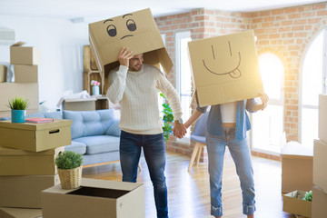 Fototapeta na wymiar Funny couple wearing cardboard boxes with fun crazy emoji faces over head