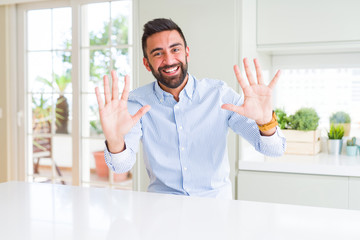 Handsome hispanic business man showing and pointing up with fingers number ten while smiling confident and happy.