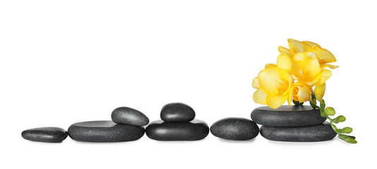 Grey spa stones and fresh flowers isolated on white