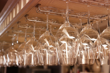 Fototapeta na wymiar Set of empty clean glasses on bar racks