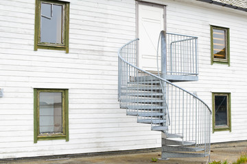 An outdoor spiral staircase leads to the door to the second floor.