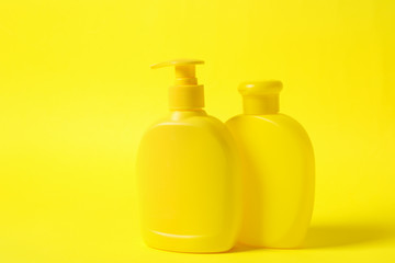 Bottles of shampoo on yellow background. Natural cosmetic products