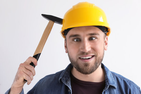 Funny Young Working Man In Hardhat With Hammer On White Background