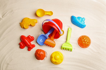 Flat lay composition with colorful beach toys on sand