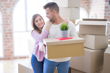 Fototapeta na wymiar Young beautiful couple in love moving to new home, holding cardboard boxes very happy and cheerful for new apartment