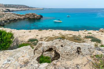 Fototapeta na wymiar Hole in the stone on the shore of the blue lagoon.