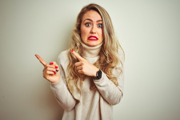 Beautiful woman wearing winter turtleneck sweater over isolated white background Pointing aside...