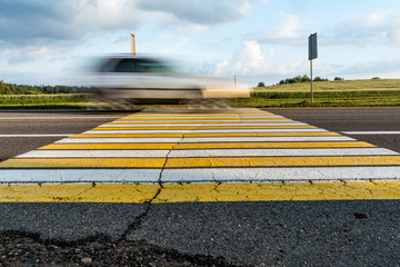 road marking pedestrian crossing on cracked asphalt, moving car through pedestrian crossing or zebra lines