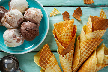 ice cream and waffle cones on turquoise wooden surface