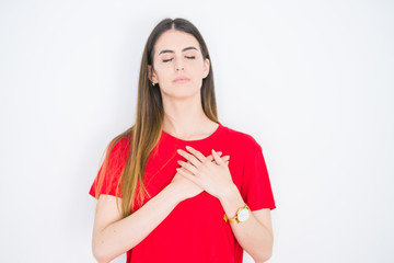Young beautiful woman wearing casual red t-shirt over white isolated background smiling with hands on chest with closed eyes and grateful gesture on face. Health concept.