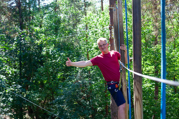 man on a tree top level in adventure rope park