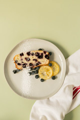 Slice of Iced Lemon Blueberry Loaf Breakfast / Dessert, Pale Green Background, Styled Shot, Top View Flat Lay