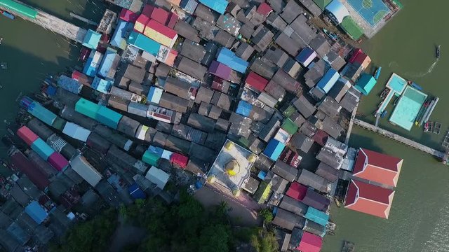 A birds eye view of a rural settlement surrounded by water and nearby islands in Thailand