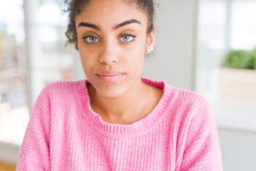 Beautiful young african american woman with afro hair Relaxed with serious expression on face. Simple and natural with crossed arms