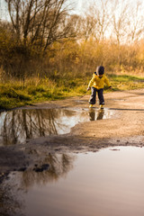 Little boy playing in the puddles after rain