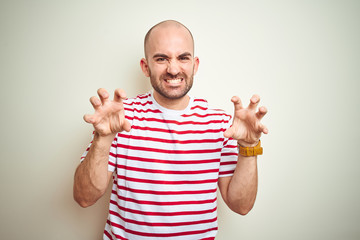 Young bald man with beard wearing casual striped red t-shirt over white isolated background smiling...