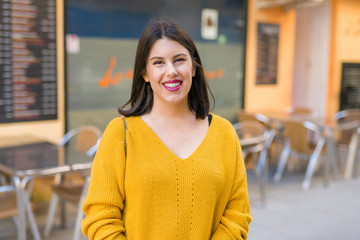 Beautiful young woman smiling cheerful walking on the street on a sunny day, casual pretty girl at the town