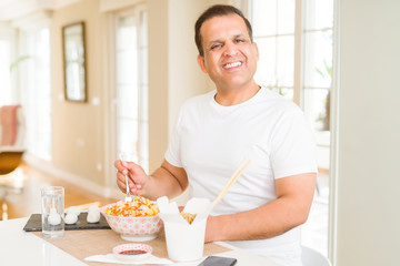 Middle age man eating asian food at home