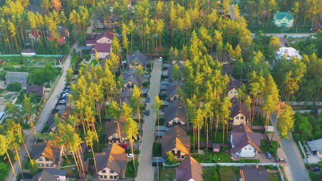 Aerial view of the residential neighborhood with the single-family homes in suburbs at sunset