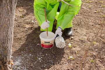Paint brush. Man paints objects in the yard. Work with color. It's time to upgrade the garden.