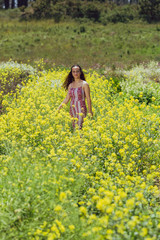 Fototapeta premium Mixed race young woman stands in a flower field on a farm