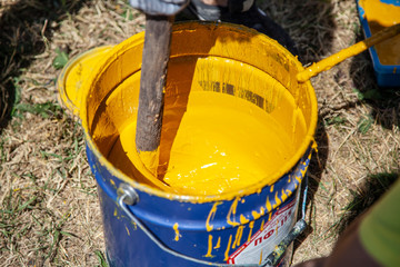 Paint brush. Man paints objects in the yard. Work with color. It's time to upgrade the garden.