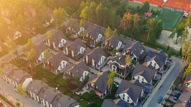 Aerial look-down view of residential neighborhood with the single-family homes in suburbs at sunset