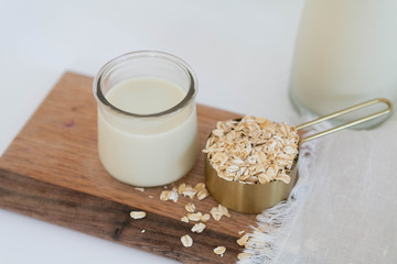Homemade Oat Milk Glass and Oats with Jug of Milk, White Background, Copy Space