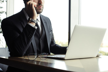 Close up of handsome businessman, working on laptop in restaurant