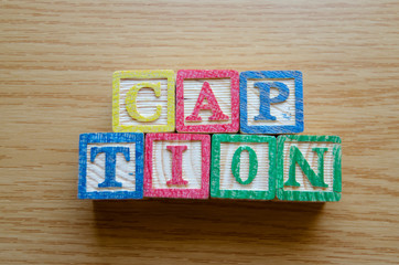 Educational toy cubes with letters organised to display word CAPTION - editing metadata and Search engine optimisation concept