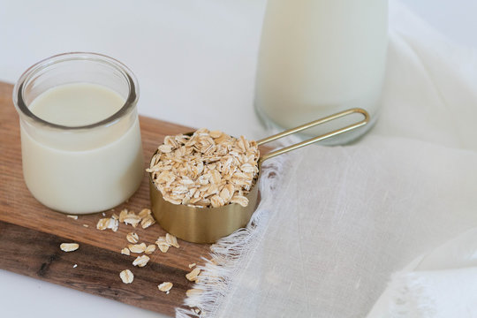 Homemade Oat Milk Glass and Oats with Jug of Milk, White Background, Copy Space