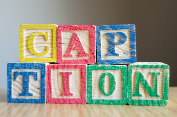 Educational toy cubes with letters organised to display word CAPTION - editing metadata and Search engine optimisation concept