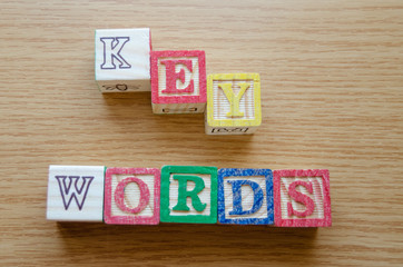 Educational toy cubes with letters organised to display word KEYWORDS - editing metadata and Search engine optimisation concept