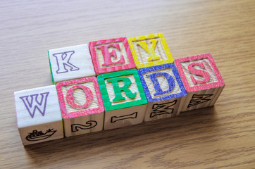 Educational toy cubes with letters organised to display word KEYWORDS - editing metadata and Search engine optimisation concept