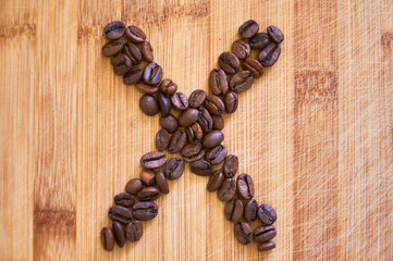 Alphabet letter X made from roasted coffee beans, 3D rendering on wooden table background