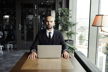 Close up of handsome businessman, working on laptop in restaurant