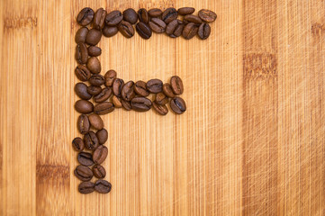 Alphabet letter F made from roasted coffee beans, 3D rendering on wooden table background