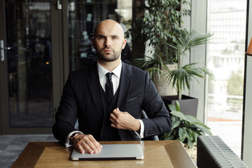 Close up of handsome businessman, working on laptop in restaurant