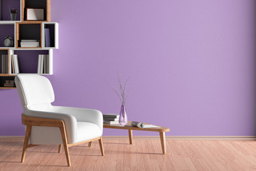 Interior of living room with white leather armchair and wooden triangular coffee table