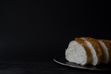 sliced fresh bread on black background