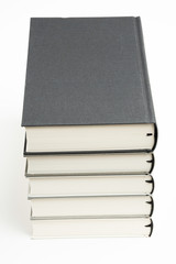 A set of five neatly stacked and arranged monochromatic cloth-bound books on a plain white background.