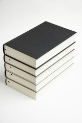 A set of five neatly stacked and arranged monochromatic cloth-bound books on a plain white background.