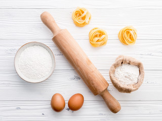 Fototapeta na wymiar Ingredients for homemade pasta flour and eggs on wooden background.