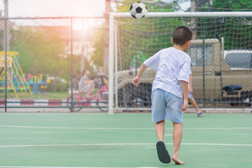 Children are wearing slippers playing football With blurred background to show movement.To exercise After school.