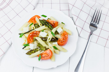 Penne pasta with tomatoes and asparagus.