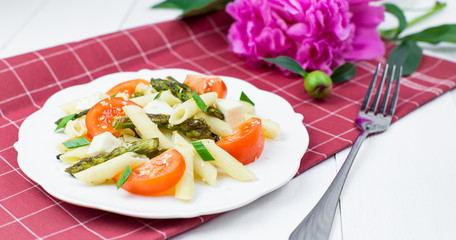 Penne pasta with tomatoes and asparagus.
