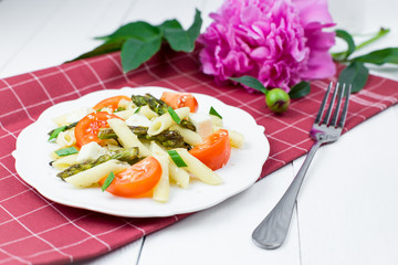 Penne pasta with tomatoes and asparagus.