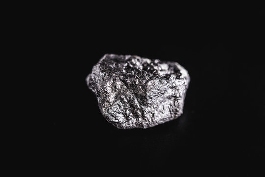 big silver nugget on black background. Raw silver stone, native silver nugget from Liberia, isolated on black background. Mineral extraction.